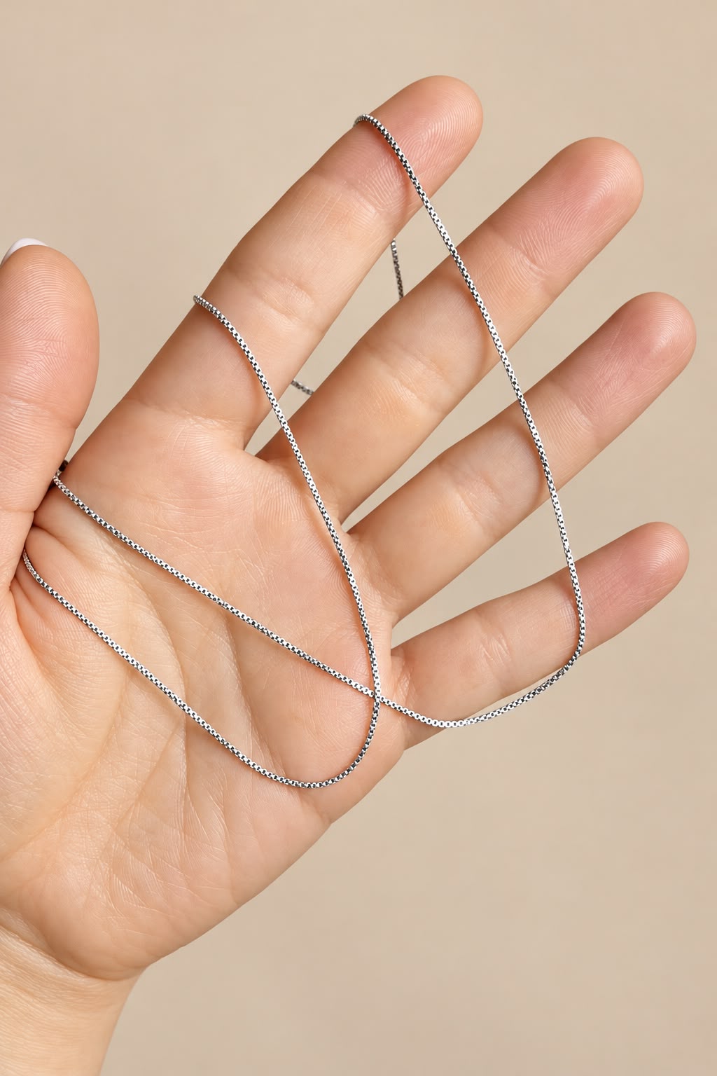 Box chain draped across a hand